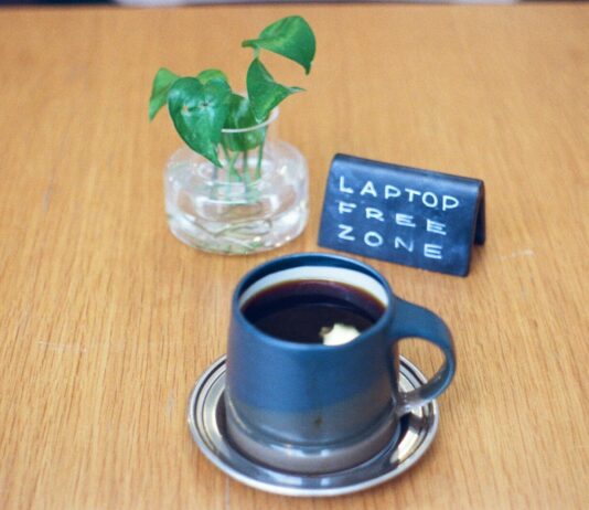 현대인의 숙면, 디지털 디톡스와 아침 루틴이 좌우한다 A mug of coffee with a plant and sign